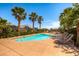 Beautiful community pool with lounge chairs surrounded by lush palm trees on a sunny day at 10476 Tyler Park Ave, Las Vegas, NV 89135