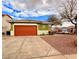 Charming single-story home featuring an orange garage door and gravel landscaping at 1080 Laguna Park Ct, Las Vegas, NV 89110