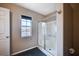 Bathroom with a glass-enclosed shower, window with blinds, and black tile flooring at 11092 Abbeyfield Rose Dr, Henderson, NV 89052