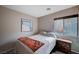Bedroom with a white bedspread, a patterned quilt, and a side table with a lamp at 11092 Abbeyfield Rose Dr, Henderson, NV 89052