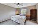 Bedroom featuring a ceiling fan, dresser, and comfortable bed with window view at 11092 Abbeyfield Rose Dr, Henderson, NV 89052