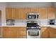 Well-lit kitchen features stainless steel appliances and wooden cabinets at 11092 Abbeyfield Rose Dr, Henderson, NV 89052