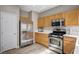 Bright kitchen featuring stainless steel appliances, wooden cabinets, and light countertops at 11092 Abbeyfield Rose Dr, Henderson, NV 89052