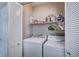This laundry room is equipped with a washer, dryer, and storage shelves behind bifold doors at 11092 Abbeyfield Rose Dr, Henderson, NV 89052