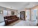 Comfortable living room with a plush leather sofa and ample natural light, creating a cozy and inviting atmosphere at 11092 Abbeyfield Rose Dr, Henderson, NV 89052