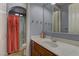 Cozy bathroom featuring a single vanity, toilet, and walk-in shower with a red curtain at 11221 Stanwick Ave, Las Vegas, NV 89138