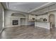 Open-concept living area with hardwood floors, stone fireplace, and adjacent modern kitchen with granite island at 11221 Stanwick Ave, Las Vegas, NV 89138