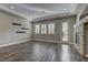 Bright living room featuring hardwood floors, a stone fireplace, and three windows with wood shutters at 11221 Stanwick Ave, Las Vegas, NV 89138