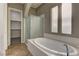 Luxurious main bathroom showcasing a modern soaking tub, a glass-enclosed shower, and a walk-in closet at 11221 Stanwick Ave, Las Vegas, NV 89138