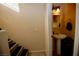 Neat powder room featuring a pedestal sink, decorative mirror, and convenient staircase access at 1505 Couples St, Las Vegas, NV 89128
