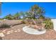 Backyard patio area featuring mature landscaping, rock garden, and a white fence at 1634 Clint Canyon Dr, Henderson, NV 89002