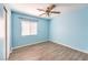 Bedroom featuring vinyl floors, blue walls, a ceiling fan, and a window for natural light at 1634 Clint Canyon Dr, Henderson, NV 89002