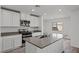 Stylish kitchen with white cabinetry, stainless steel appliances, and a spacious island with a sink at 1717 Desert Path Ave, North Las Vegas, NV 89032