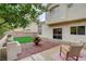 Relaxing backyard showcasing artificial turf, mature landscaping, a patio area, and a tranquil outdoor ambiance at 2033 Shining Feather Ln, Las Vegas, NV 89134