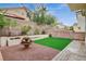 Charming backyard featuring artificial turf, a decorative fountain, and multi-level planter beds and hardscape at 2033 Shining Feather Ln, Las Vegas, NV 89134