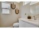 This half bathroom features a modern sink vanity, toilet, and decorative wall hangings at 2033 Shining Feather Ln, Las Vegas, NV 89134