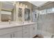 Bright bathroom featuring double sinks, tiled shower, and modern finishes at 2033 Shining Feather Ln, Las Vegas, NV 89134