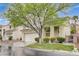 Attractive two-story home featuring a well-maintained lawn, mature tree, and attached two-car garage at 2033 Shining Feather Ln, Las Vegas, NV 89134