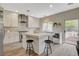 A modern kitchen featuring white cabinetry, stainless steel appliances, an island, and backyard access at 2033 Shining Feather Ln, Las Vegas, NV 89134