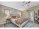 Bright bedroom features neutral paint colors, an ensuite bath, a ceiling fan, and wood-look flooring at 2033 Shining Feather Ln, Las Vegas, NV 89134