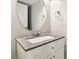 Bathroom featuring a round mirror, gray countertop, white cabinets, and modern fixtures at 2337 Ivory Point Ct, Las Vegas, NV 89134