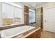 A luxurious bathroom featuring a soaking tub beneath a window and a glass-enclosed shower at 2337 Ivory Point Ct, Las Vegas, NV 89134