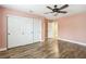 A charming bedroom featuring hardwood floors, large closet doors, and a ceiling fan at 2337 Ivory Point Ct, Las Vegas, NV 89134