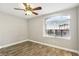 A simple bedroom with hardwood floors, a window, and a ceiling fan at 2337 Ivory Point Ct, Las Vegas, NV 89134