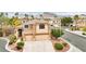 Aerial view of the home with three-car garage, well maintained landscaping, and mountain views at 2337 Ivory Point Ct, Las Vegas, NV 89134