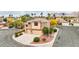 Front aerial view of a two-story home with a three car garage and desert landscaping at 2337 Ivory Point Ct, Las Vegas, NV 89134