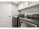 Laundry room with gray washer and dryer and white cabinets for storage at 2337 Ivory Point Ct, Las Vegas, NV 89134