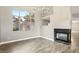 Living room with wood floors, fireplace, large window and modern chandelier at 2337 Ivory Point Ct, Las Vegas, NV 89134