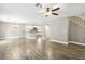 Open living room boasts wood floors, chandelier, fan, and flows into the kitchen at 2337 Ivory Point Ct, Las Vegas, NV 89134