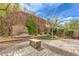 Serene backyard oasis with a stone patio, water fountain, and lush greenery at 2413 Hamonah Dr, Henderson, NV 89044