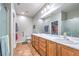 Bathroom featuring double sinks, wood cabinets, a full-length mirror, and a glass-enclosed shower at 2413 Hamonah Dr, Henderson, NV 89044
