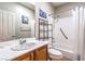 Well-lit bathroom with a shower-tub combo, framed mirror and a vanity that has ample counter space at 2413 Hamonah Dr, Henderson, NV 89044