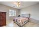 Comfortable bedroom showcasing a tufted headboard, shuttered window, ceiling fan and hard surface floors at 2413 Hamonah Dr, Henderson, NV 89044