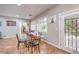 Bright dining room features a modern glass top table, plantation shutters, and access to the backyard at 2413 Hamonah Dr, Henderson, NV 89044