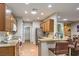 Well-lit kitchen with breakfast bar, oak cabinets, and stainless steel refrigerator at 2413 Hamonah Dr, Henderson, NV 89044