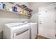 Efficient laundry room with washer, dryer, and shelving for organized storage at 2413 Hamonah Dr, Henderson, NV 89044