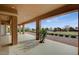 Covered patio with stucco columns, neutral color scheme, and rock landscaping with a green space view at 2740 High Range Dr, Las Vegas, NV 89134