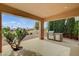 Covered patio features a built-in grill and views of the lush green space and landscaping at 2740 High Range Dr, Las Vegas, NV 89134