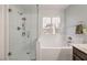 Bright bathroom featuring a glass shower enclosure, soaking tub, and a window offering natural light at 2810 Lava Rock Ave, North Las Vegas, NV 89031