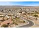 This aerial captures a lovely home, solar panels, and community nestled in a quiet neighborhood with city views at 319 Belfast St, Henderson, NV 89015