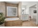 Bathroom with soaking tub, window and double sink vanity at 319 Belfast St, Henderson, NV 89015