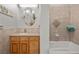 Cozy bathroom featuring a wood cabinet vanity, bathtub and tiled shower at 319 Belfast St, Henderson, NV 89015