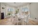Bright dining room with large windows and a modern white table with white chairs at 319 Belfast St, Henderson, NV 89015