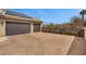 Spacious two-car garage with a wide paver driveway and solar panels on the roof in a private setting at 319 Belfast St, Henderson, NV 89015