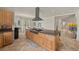 Open kitchen featuring a large island with gas cooktop and modern vent hood at 319 Belfast St, Henderson, NV 89015