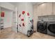 Spacious laundry room with modern washer, dryer, tile floors, storage, and poppy wall decor at 319 Belfast St, Henderson, NV 89015